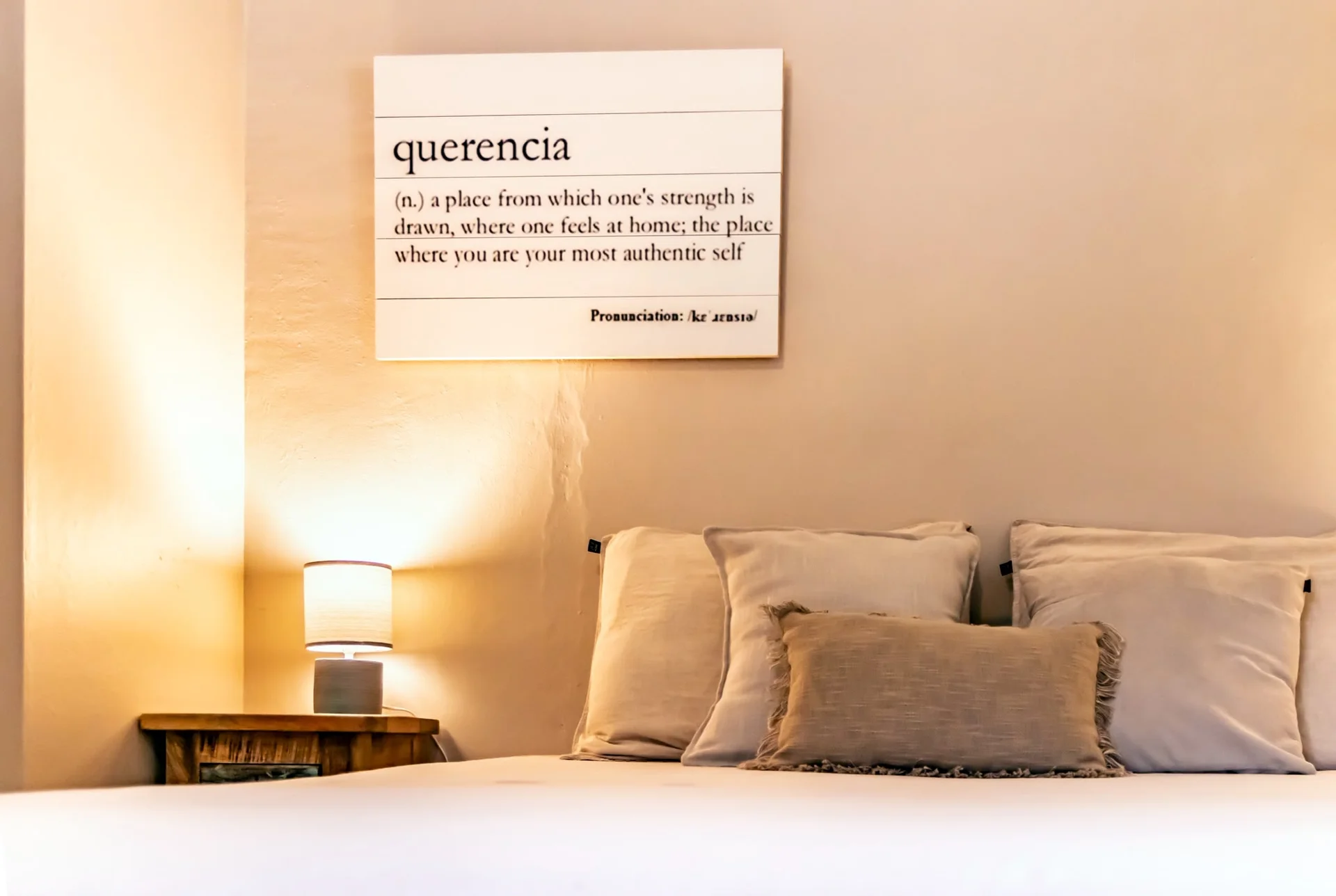 Het querencia-definitiebord boven het bed in Appartement Saars
