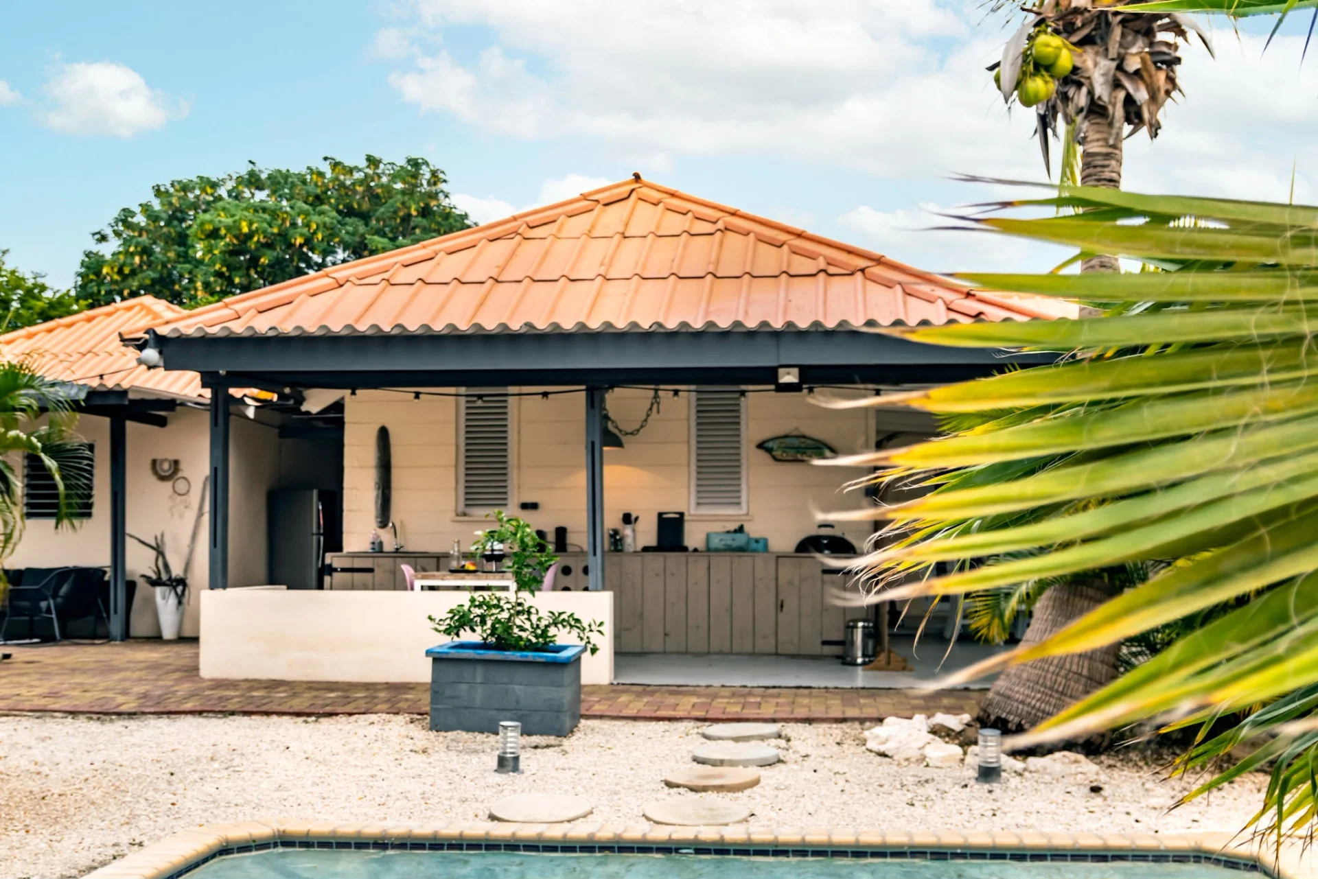 Het huis van Villa Querencia achter een groen palmblad
